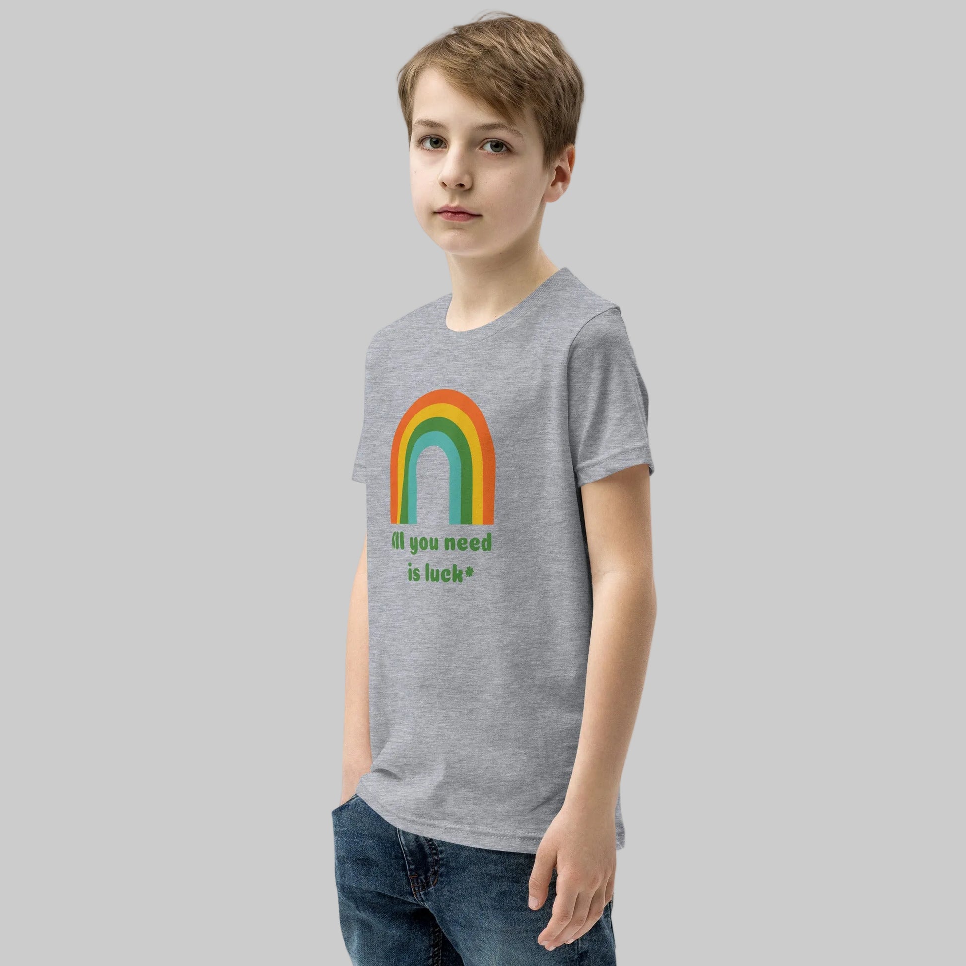 Child wearing All You Need Is Luck St Patricks Day shirt with lucky shamrock clover design on a Bella Canvas youth short sleeve t shirt. Cute kids holiday outfit ideal for school parties, St Patrick's Day parades, and festive Irish celebrations.