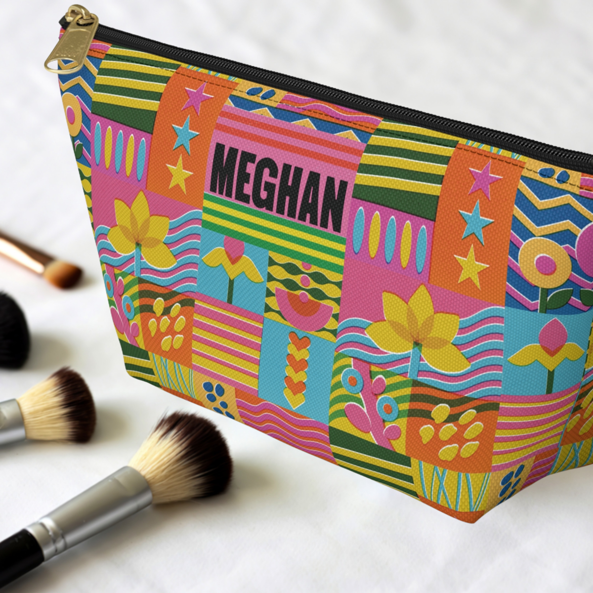 Personalized girls toiletry bag featuring a bright retro floral design filled with colorful flowers, stars, stripes, and playful geometric patterns. The custom name makes it easy to spot in a suitcase, backpack, bathroom, or camp bag. This roomy pouch can hold toothbrushes, hair accessories, toiletries, cosmetics, or other personal essentials and makes a colorful gift for girls, tweens, and teens.
