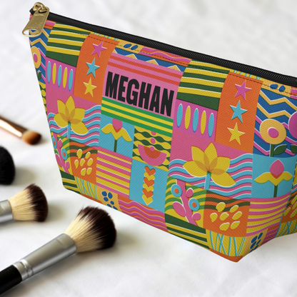 Personalized girls toiletry bag featuring a bright retro floral design filled with colorful flowers, stars, stripes, and playful geometric patterns. The custom name makes it easy to spot in a suitcase, backpack, bathroom, or camp bag. This roomy pouch can hold toothbrushes, hair accessories, toiletries, cosmetics, or other personal essentials and makes a colorful gift for girls, tweens, and teens.