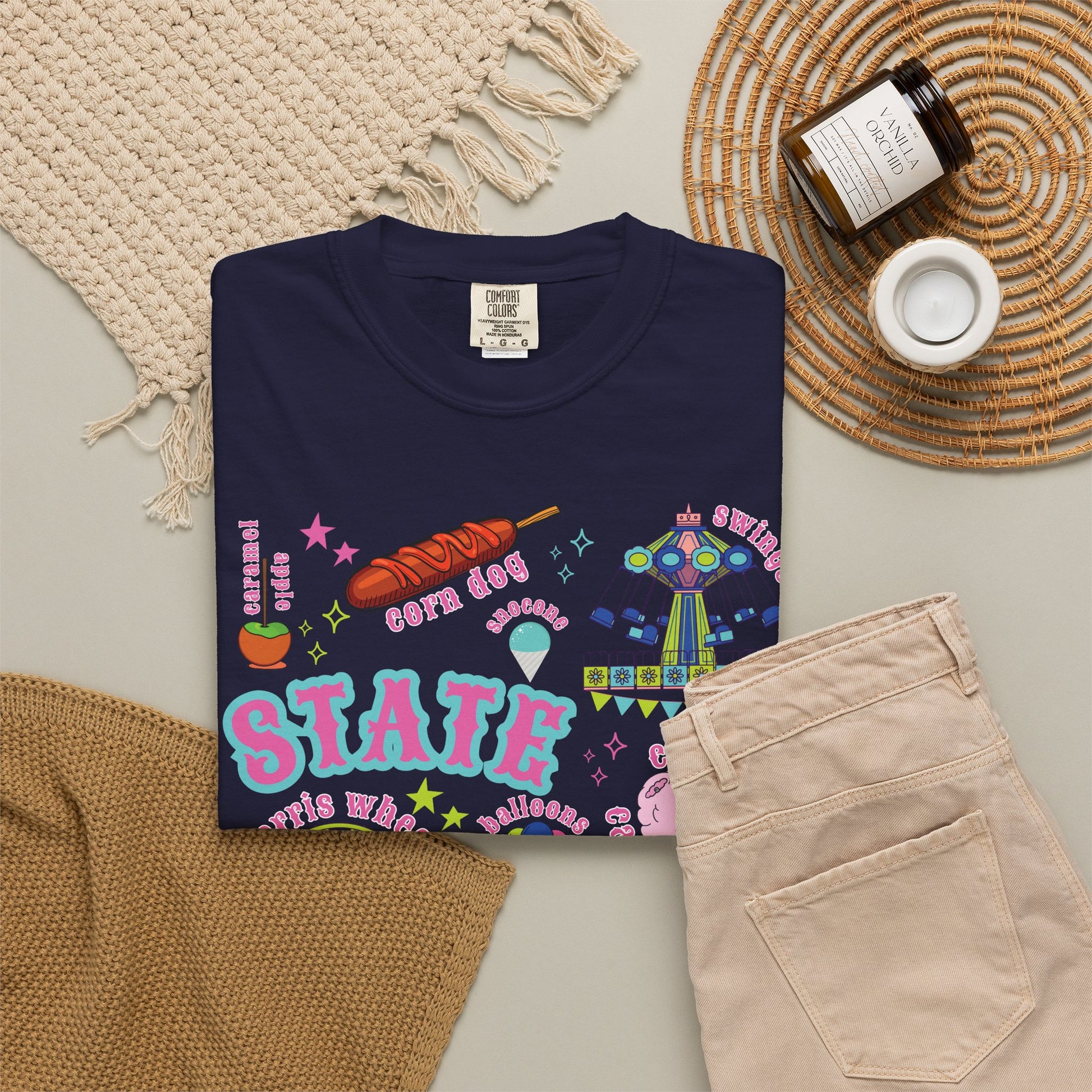 A playful carnival and state fair graphic fills the front of a Comfort Colors 1717 T shirt, combining Ferris wheel and roller coaster illustrations with cotton candy, corn dogs, funnel cake, balloons, livestock, a blue ribbon and ticket stubs in a nostalgic colorful summer fair palette with nostalgic details.