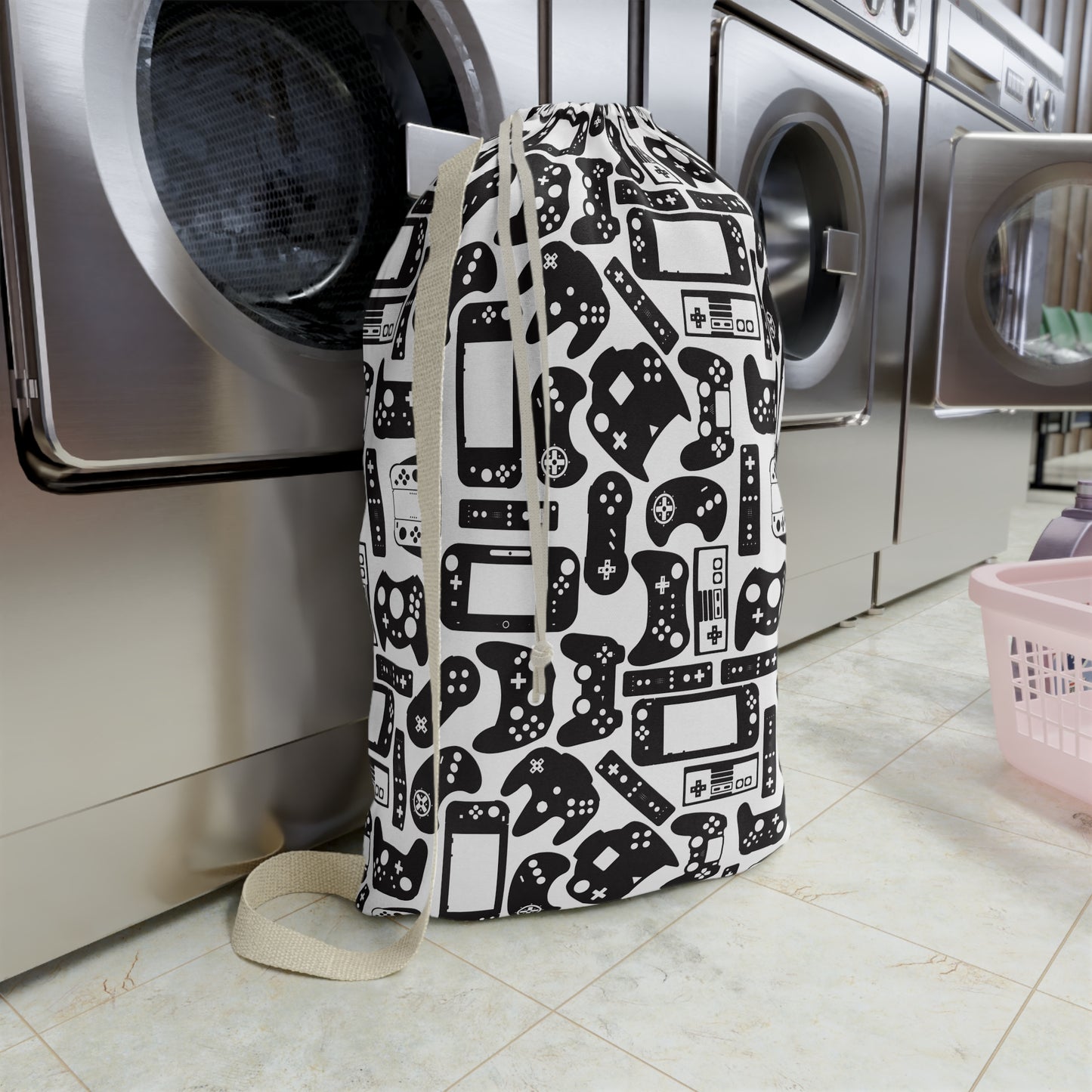 Laundry bag with gaming controller pattern in front of a washing machine in a laundry room.