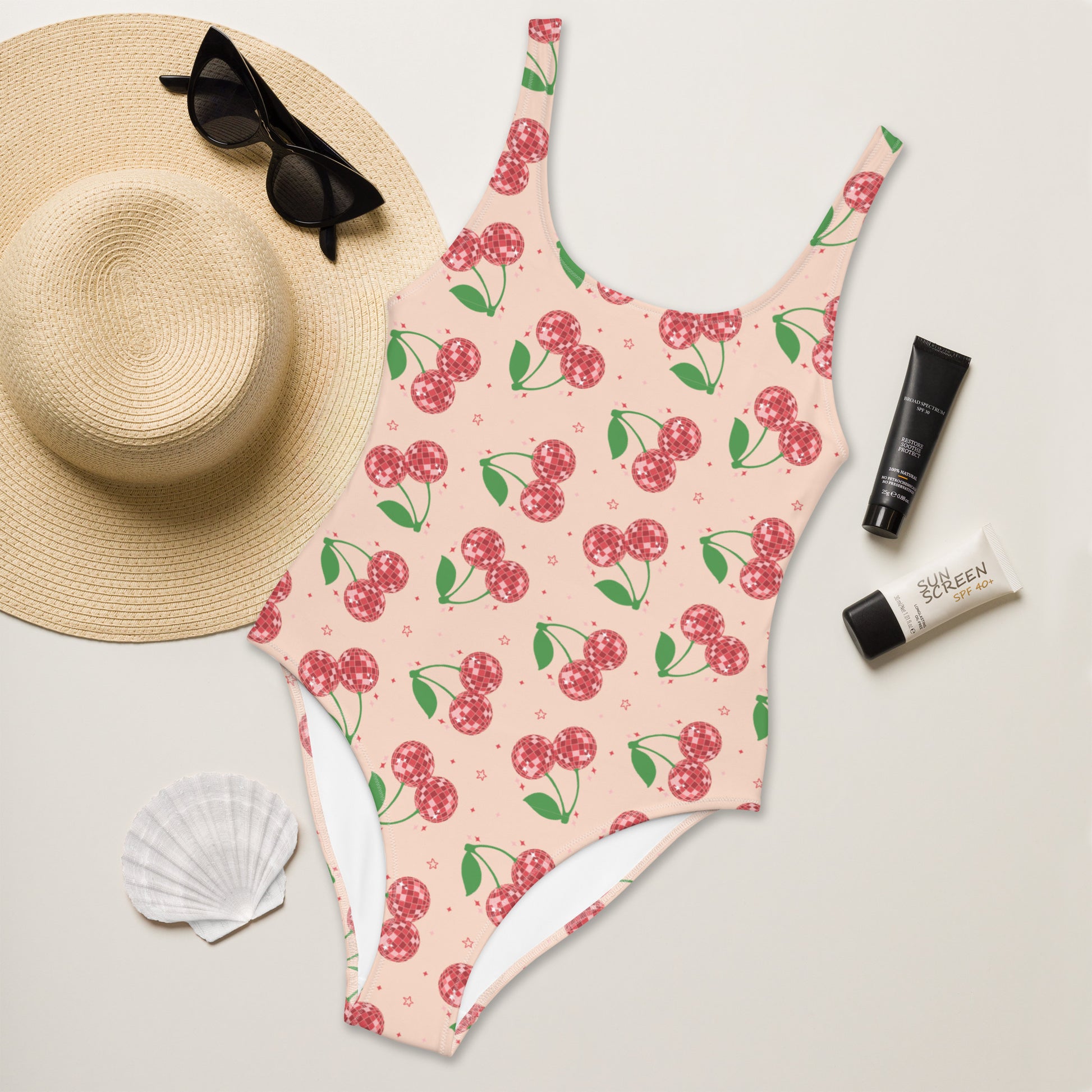 Close up detail of the red disco ball cherry pattern on the pink Disco Cherries swimsuit fabric showing the colorful retro summer design