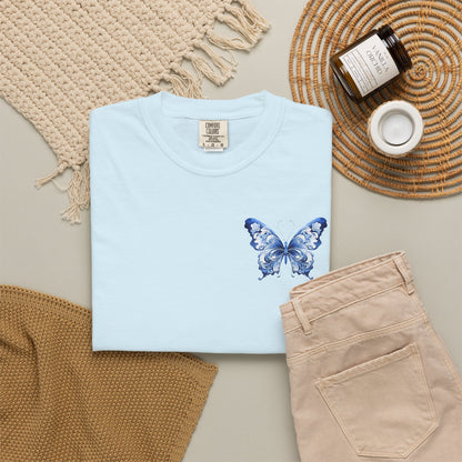 Comfort Colors women’s tee with elegant blue toile butterfly artwork on the left chest. Soft relaxed cotton shirt sold in five colors and sizes S through 4XL. Chinoiserie inspired butterfly design adds a subtle feminine statement while keeping a minimal clean look. Ideal for boutique shoppers who love coastal grandmother style, French aesthetic clothing, vintage botanical prints, comfy basics, and stylish everyday wardrobes.