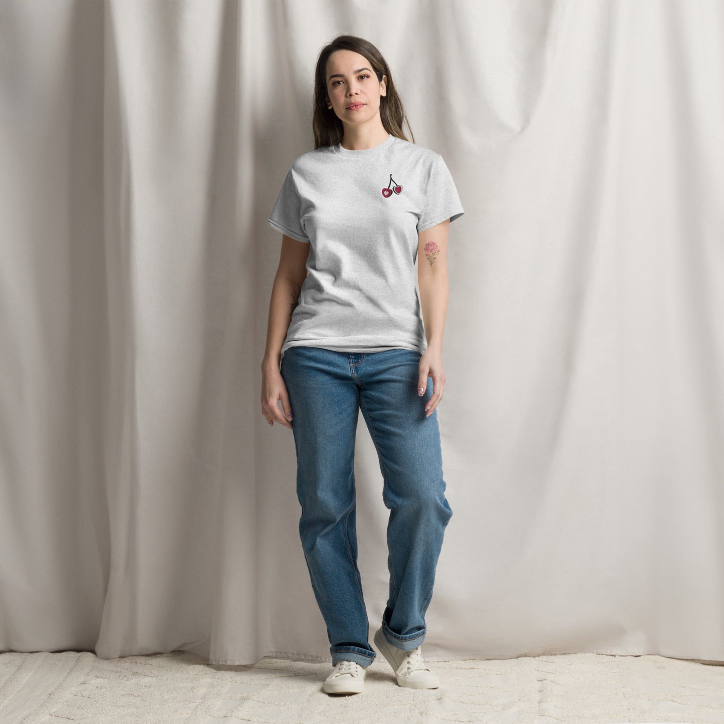 Woman wearing ash grey embroidered cherry hearts t shirt featuring red cherry heart embroidery on the front. Designed on a relaxed fit Gildan S5000 tee, this neutral everyday top is perfect for casual wear, lounging, and errands. Matching girls shirt available separately for mommy and me outfits, creating coordinated family style with a soft modern aesthetic.