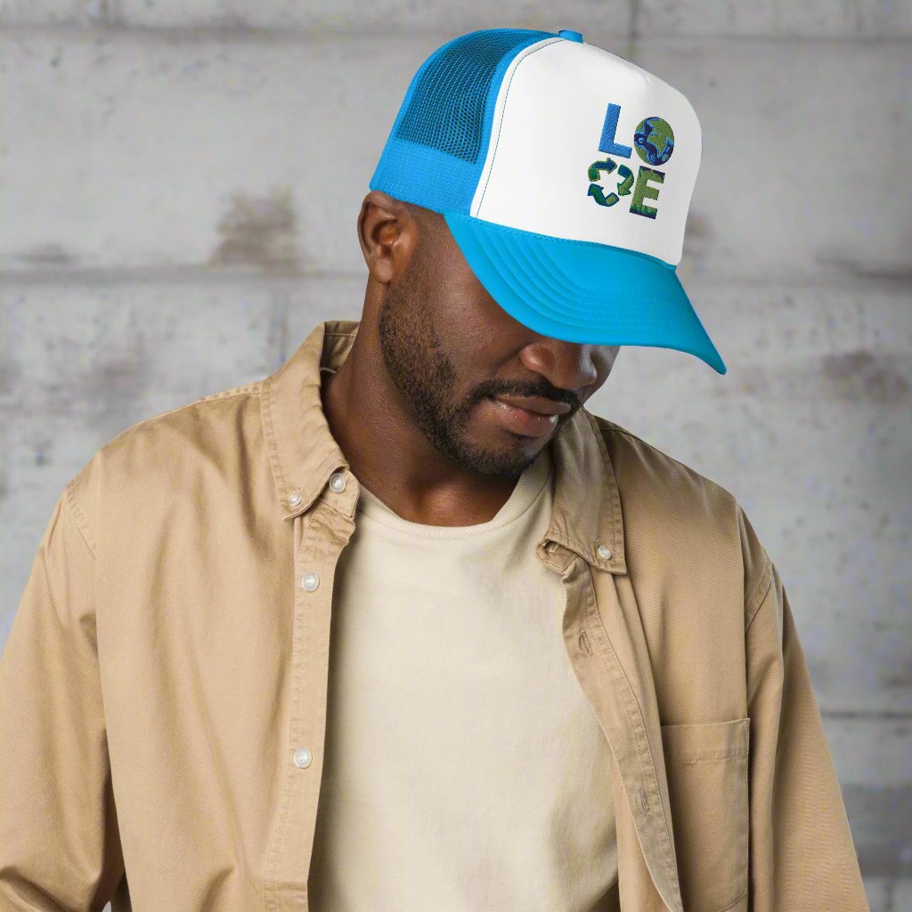 LOVE Earth Day Foam Trucker Hat, which features the letters L-O-V-E in large embroidered block letters in shades of blue and green. The hat is teal and white. The letters each represent water, earth, recycling and nature. by jaecrece.com