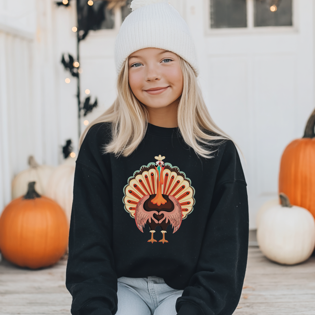 Kids Thanksgiving crewneck sweatshirt with a whimsical turkey graphic, colorful feathers and heart shaped wings, designed for cozy fall days and holiday celebrations
