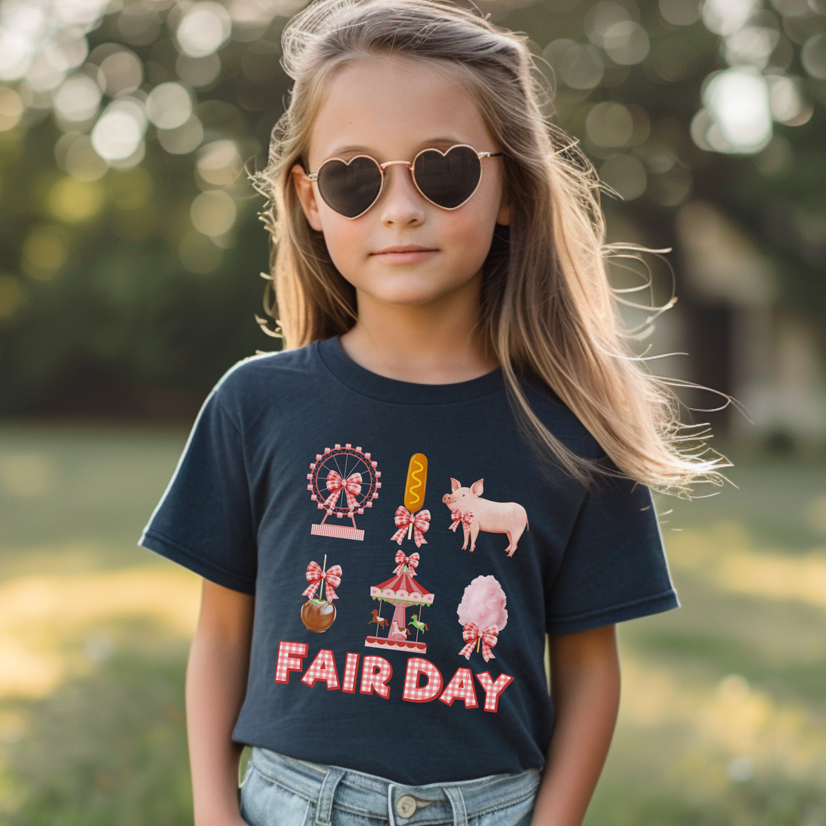 Girls carnival shirt featuring a colorful Fair Day graphic with a Ferris wheel, carousel, cotton candy, corn dog, pink pig and caramel apple. Pink gingham bows and vintage inspired details make it perfect for a fun day at the fair.