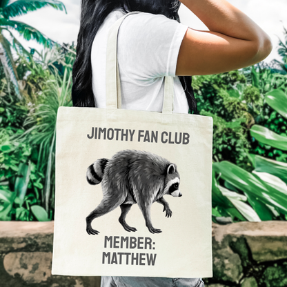 Personalized raccoon canvas tote featuring Jimothy Fan Club lettering and a custom member name printed beneath the illustrated raccoon. Funny Jimothy gift and personalized tote for viral raccoon fans, Seattle fans, animal lovers, and anyone who wants to join the Jimothy Fan Club.