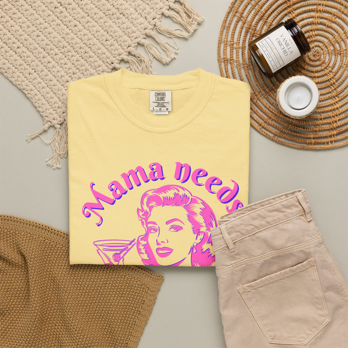 Image: A playful and stylish Mama Needs a Mocktail tshirt featuring a bright pink neon graphic of a pop art vintage mom enjoying a drink. This Comfort Colors tee, available in six color options, is a fantastic way to celebrate pregnancy, sobriety, or the choice to go alcohol free. Whether worn at a baby shower or a mocktail happy hour, this shirt brings humor and positivity to any setting.
