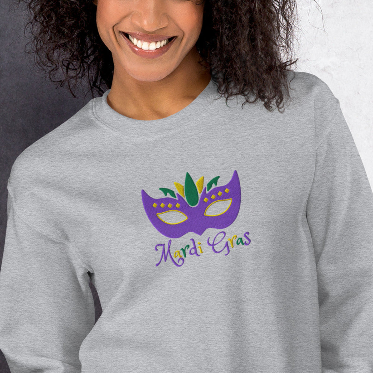 Show off your Carnival spirit in this Mardi Gras adult sweatshirt, available in sizes S–5XL, featuring a detailed embroidered purple, green, and gold mask and festive lettering. Whether you’re exploring the French Quarter or attending a NOLA event, this comfortable sweatshirt makes a perfect New Orleans souvenir and doubles as a stylish, family-friendly group outfit.