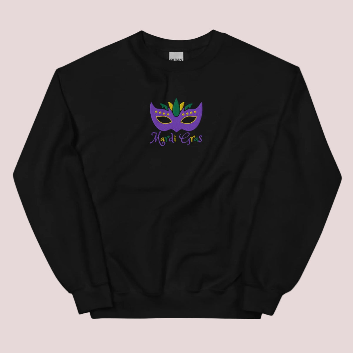 Bring home the spirit of New Orleans with this cozy Mardi Gras sweatshirt for adults. Featuring detailed embroidery of a Carnival mask in purple, green, and gold and festive “Mardi Gras” text, this top is great for NOLA lovers, parade-goers, or themed parties. Available in sizes S–5XL, it’s perfect for matching family outfits and French Quarter fashion.