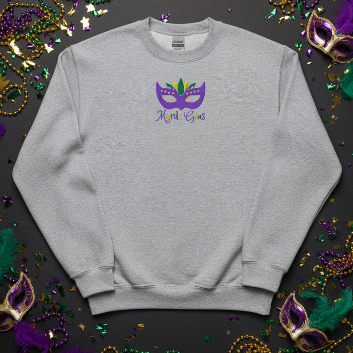 Dress your child in the spirit of Mardi Gras with this embroidered sweatshirt, featuring a bright carnival mask and classic Mardi Gras text in purple, green, and gold. Youth sizes XS–XL are perfect for school events or parade days. Coordinate with matching adult sweatshirts for family Mardi Gras outfit moments. Ideal for shoppers looking for kids Mardi Gras shirts, holiday apparel, or festive youth sweatshirts.