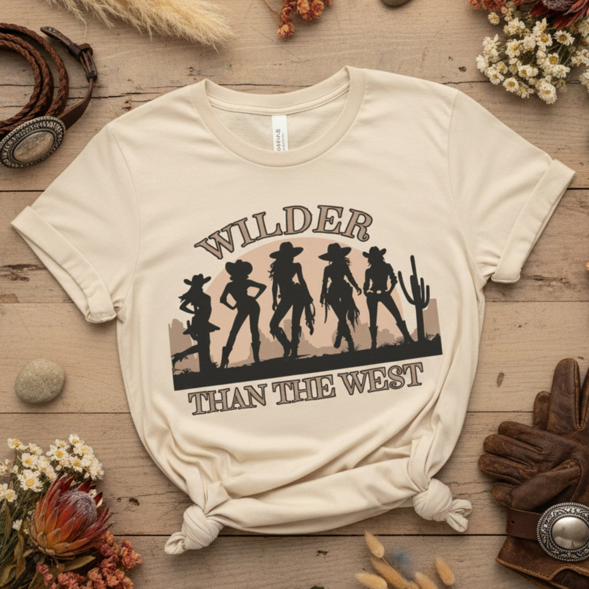 Wilder than the West youth girls tee shows five cowgirls against a desert backdrop and bold sunset. A western cowgirl silhouette shirt with a soft, lived-in look and natural color. Ideal for music festival rodeo events, state fairs, and girls who love a country vibe. This mommy and me match tee for toddlers, girls, and women is perfect for mini horse lovers, coquette outfits, and bachelorette trip groups.