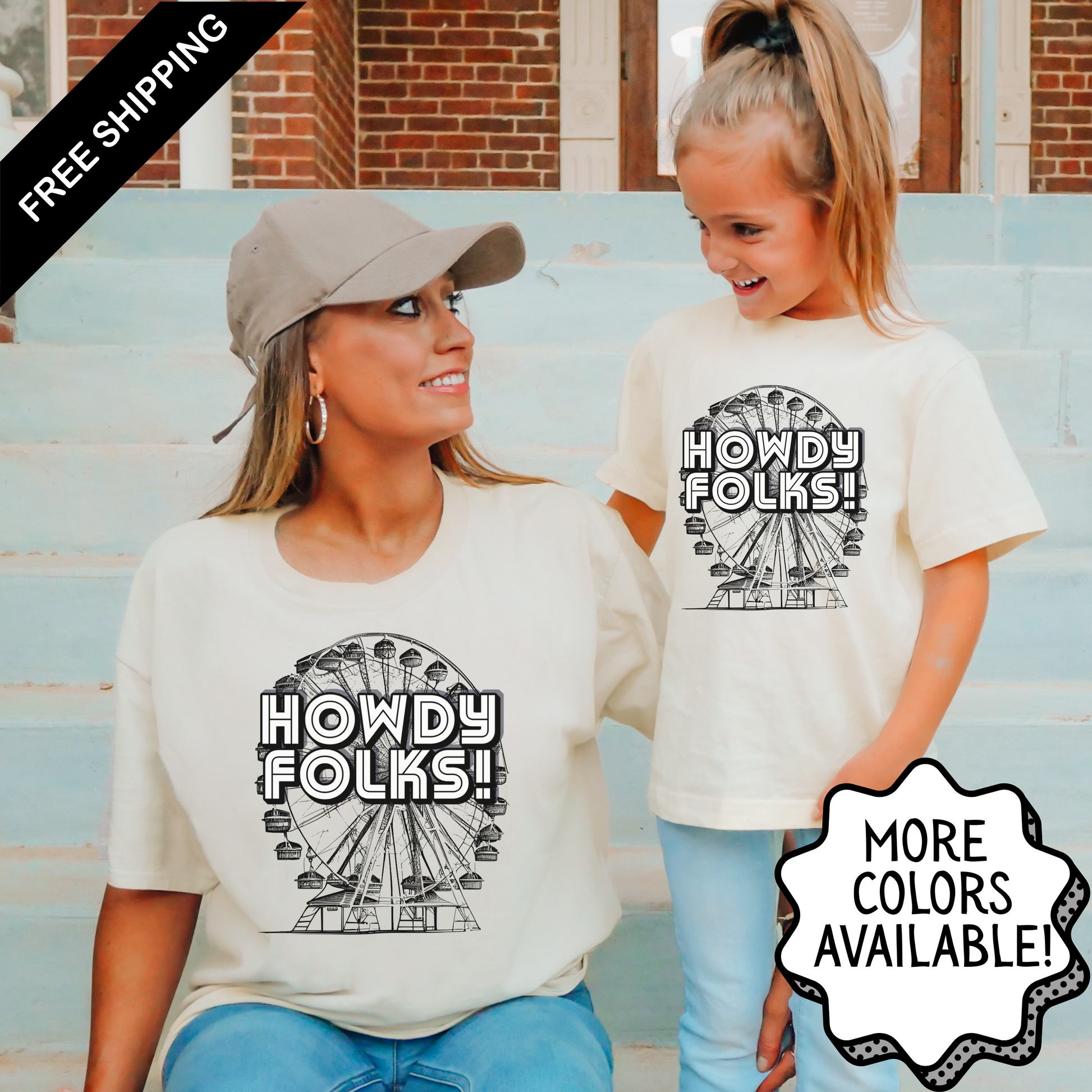 Mom and daughter wearing matching Howdy Folks t shirts featuring a vintage Ferris wheel graphic and bold retro lettering. The casual family outfit captures a fun fair inspired style perfect for state fairs, county fairs, festivals, and family outings. Adult and child sizes are available for an easy coordinated look.