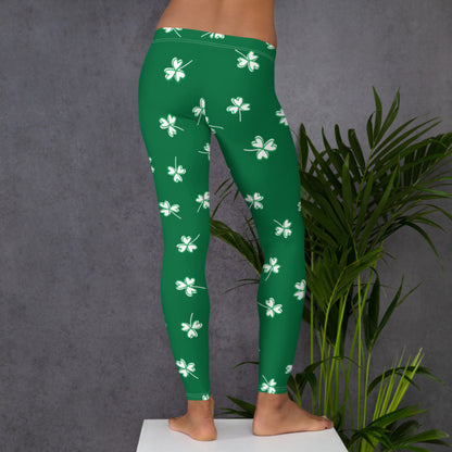 Family matching St. Patrick's Day leggings featuring white four leaf clovers on a bright green background with sizes available for moms, kids, toddlers, and tweens