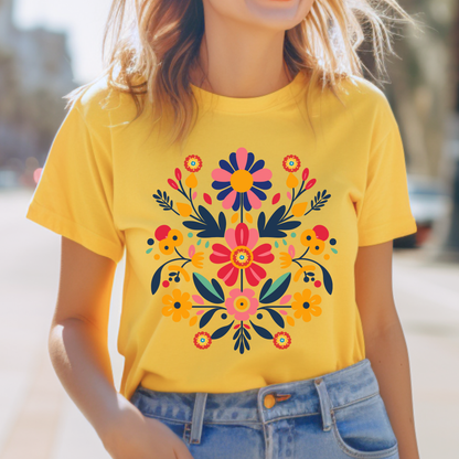 Daisy yellow Gildan 64000 Softstyle tee featuring a bright and colorful Otomi inspired floral design. The cheerful yellow shirt pairs with the vibrant Mexican folk art artwork for a playful, colorful look that works especially well for sunny everyday outfits, fiestas, Hispanic Heritage Month celebrations, family photos, cultural events, and anyone who loves Mexican inspired floral clothing.