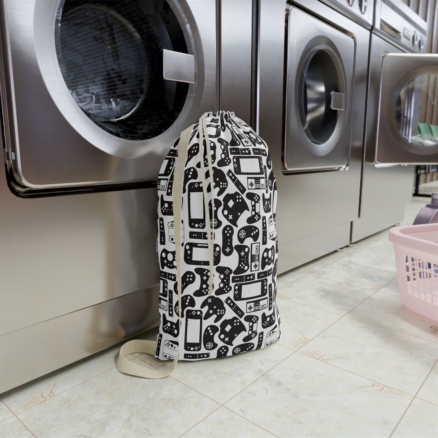 Laundry bag with gaming console pattern in front of a washing machine in a laundry room.