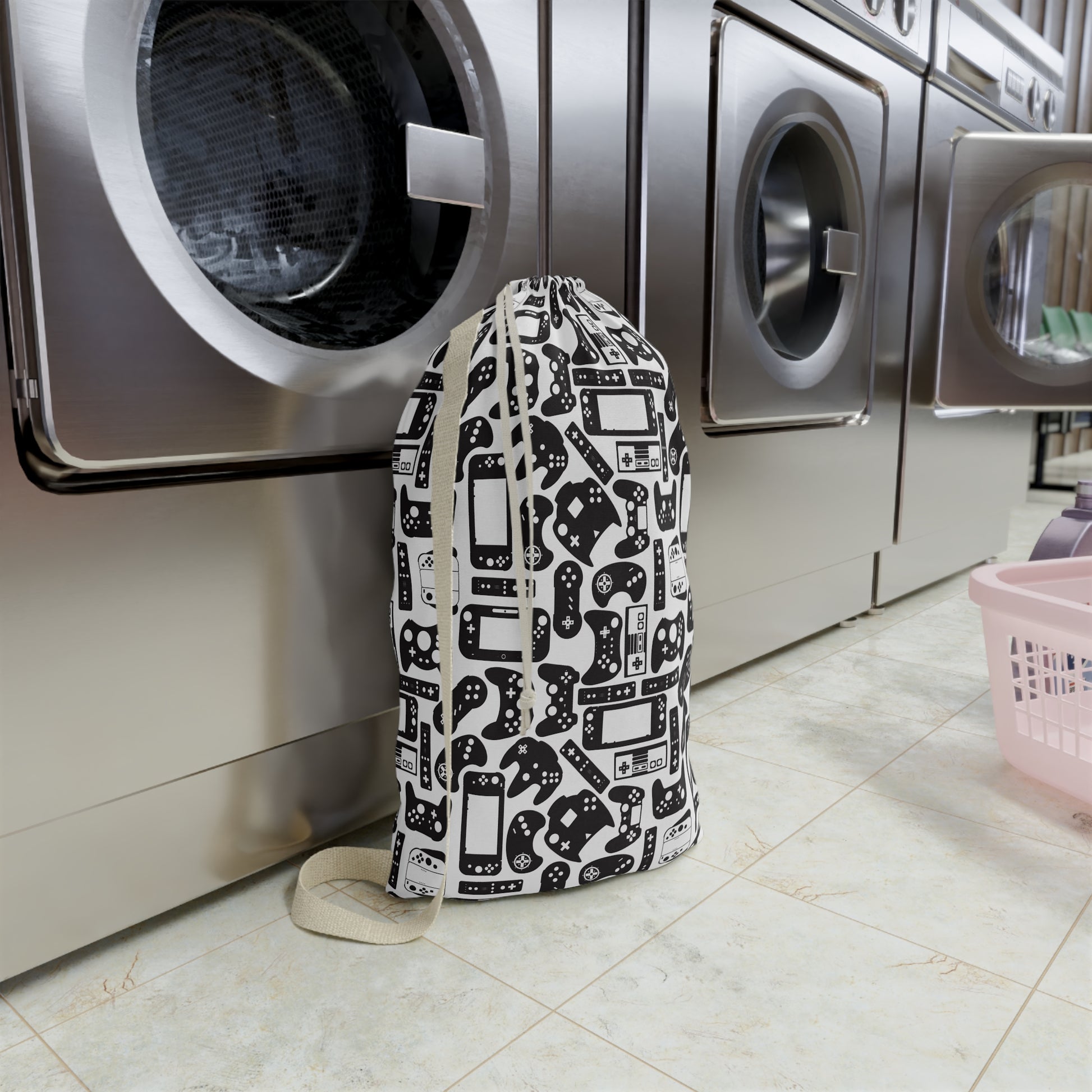 Laundry bag with gaming console pattern in front of a washing machine in a laundry room.