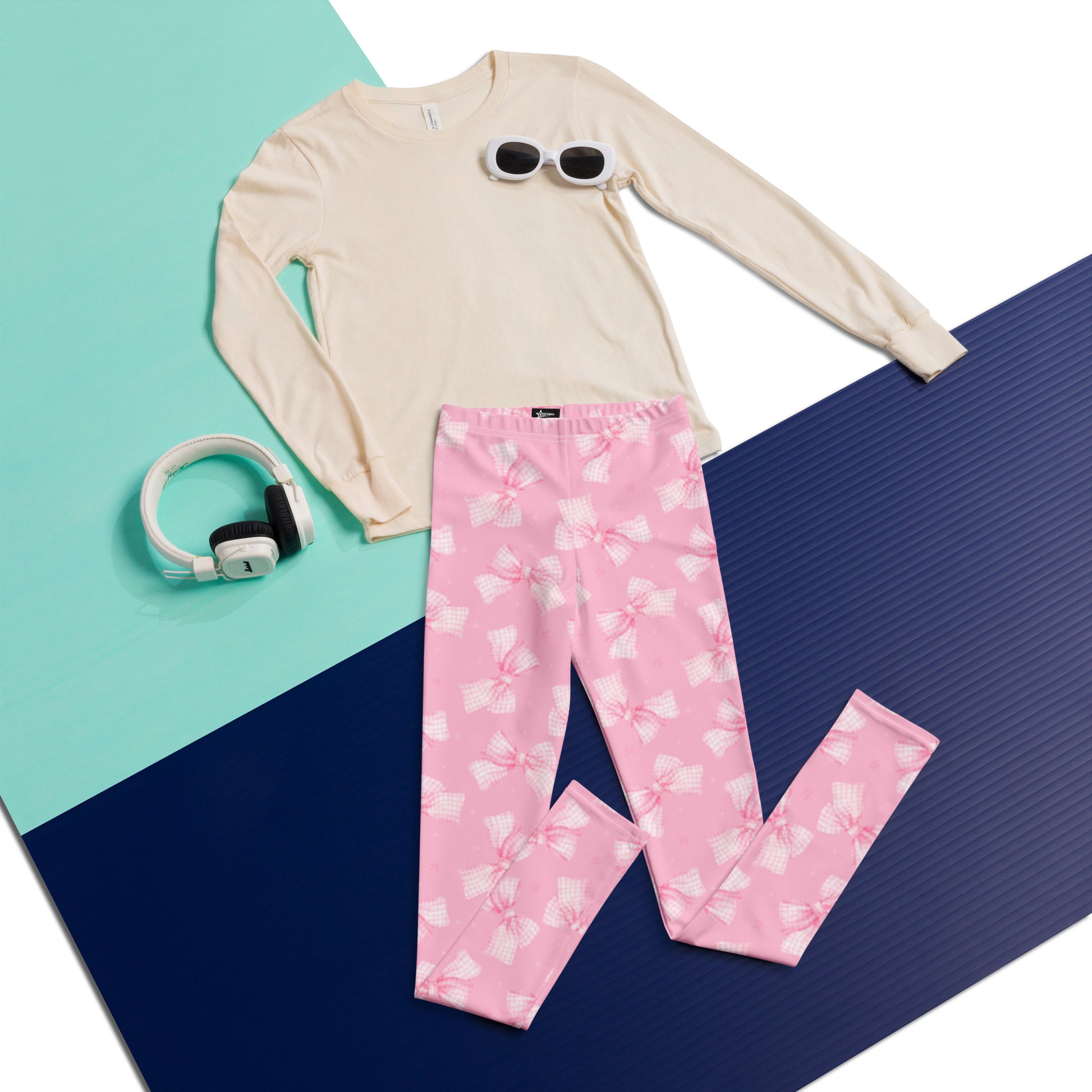 Image: These pink coquette leggings for youth come in sizes 8 to 20 and feature an all-over gingham bow print that gives off sweet and stylish energy. Great for girls who love charming fashion, they are comfortable enough for school or dance and cute enough for party outfits. An ideal gift for trendsetting teens and tweens, by jaecrece.