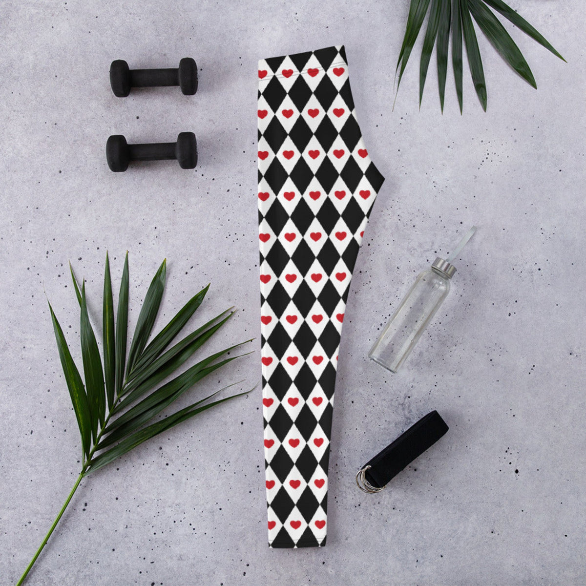 Women's black and white harlequin leggings decorated with red hearts create a playful Valentine's Day outfit. The bold pattern adds personality to a simple red, pink, black, or white top and can be dressed up or down. These heart print leggings are also versatile enough to wear beyond Valentine's Day for casual outfits, festivals, parties, or themed events.