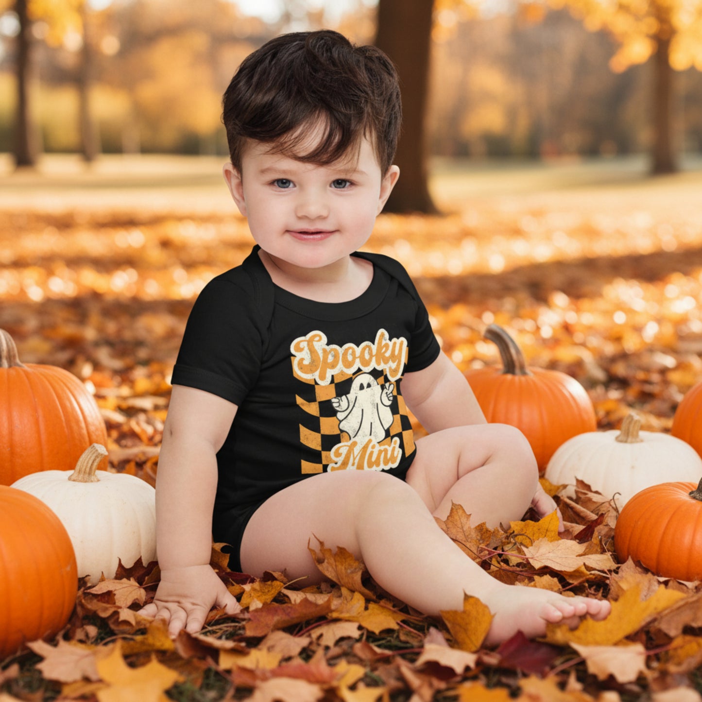 Cute black Halloween bodysuit for baby featuring a ghost, Spooky Mini Vibes lettering, and retro orange and cream graphics. Designed for little ones celebrating their first Halloween and perfect for family Halloween pictures, pumpkin patches, Halloween parties, and coordinated family outfits.