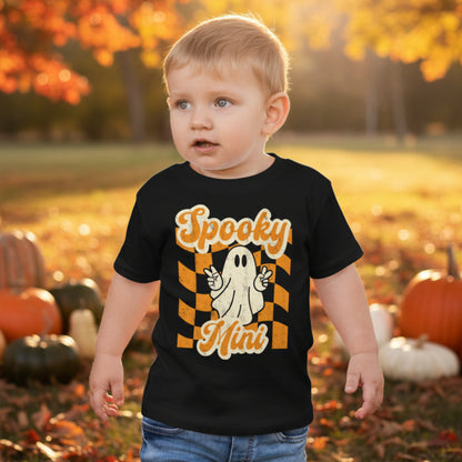 Retro inspired toddler Halloween shirt featuring a playful ghost and Spooky Mini Vibes lettering in orange and cream on black. A festive Halloween outfit for toddlers that coordinates with matching family shirts for Halloween photos, pumpkin patch adventures, and family celebrations.
