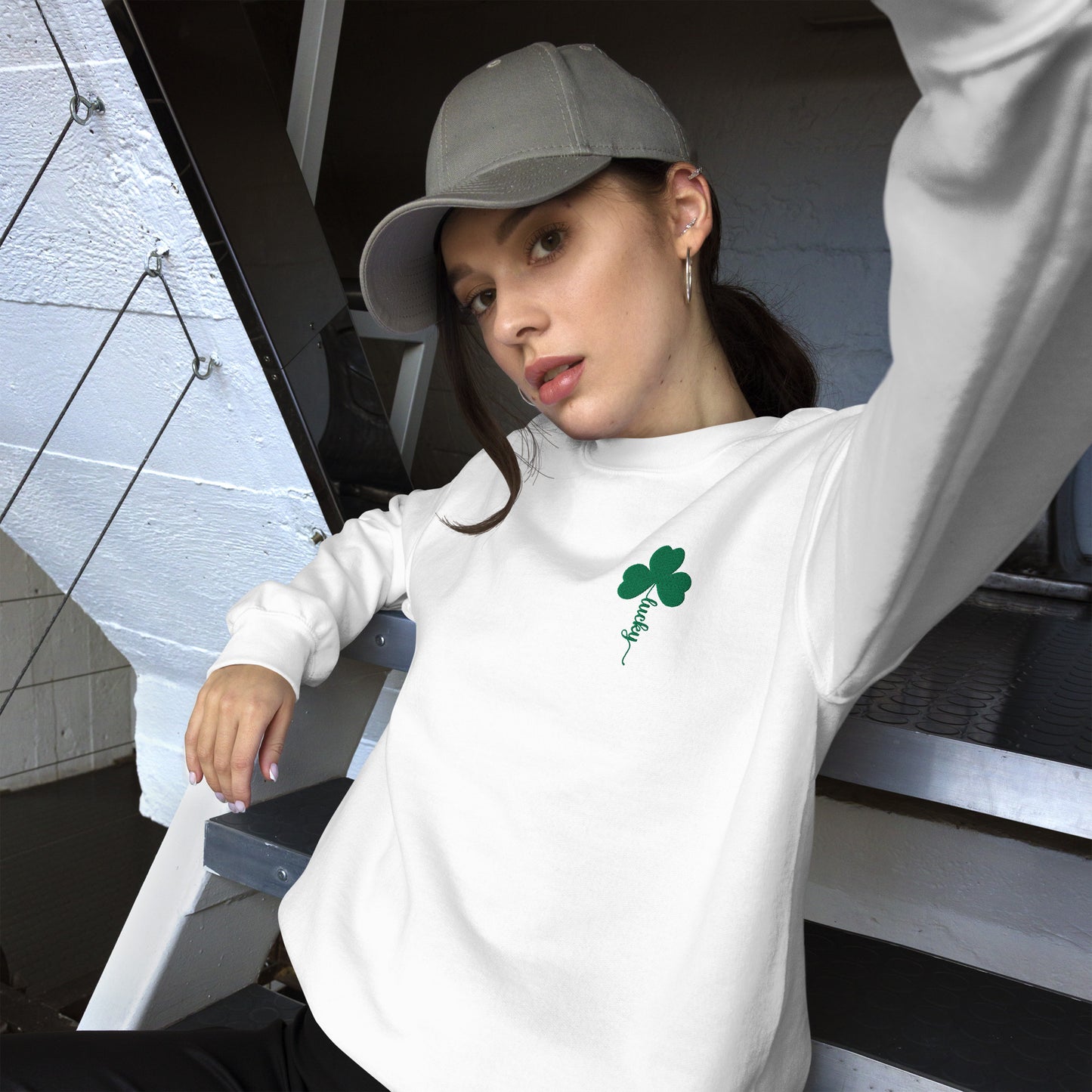 Cozy white crewneck pullover sweatshirt with embroidered green clover and Lucky script design, a festive holiday sweater for women who love subtle St. Patrick's Day style.
