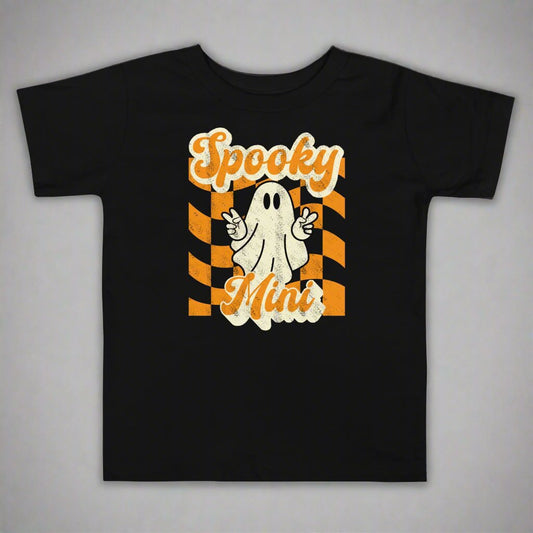 Spooky Mini Halloween Toddler Shirt, featuring a orange checkerboard pattern with a cute ghost graphic. The text reads Spooky Mini, by jaecrece