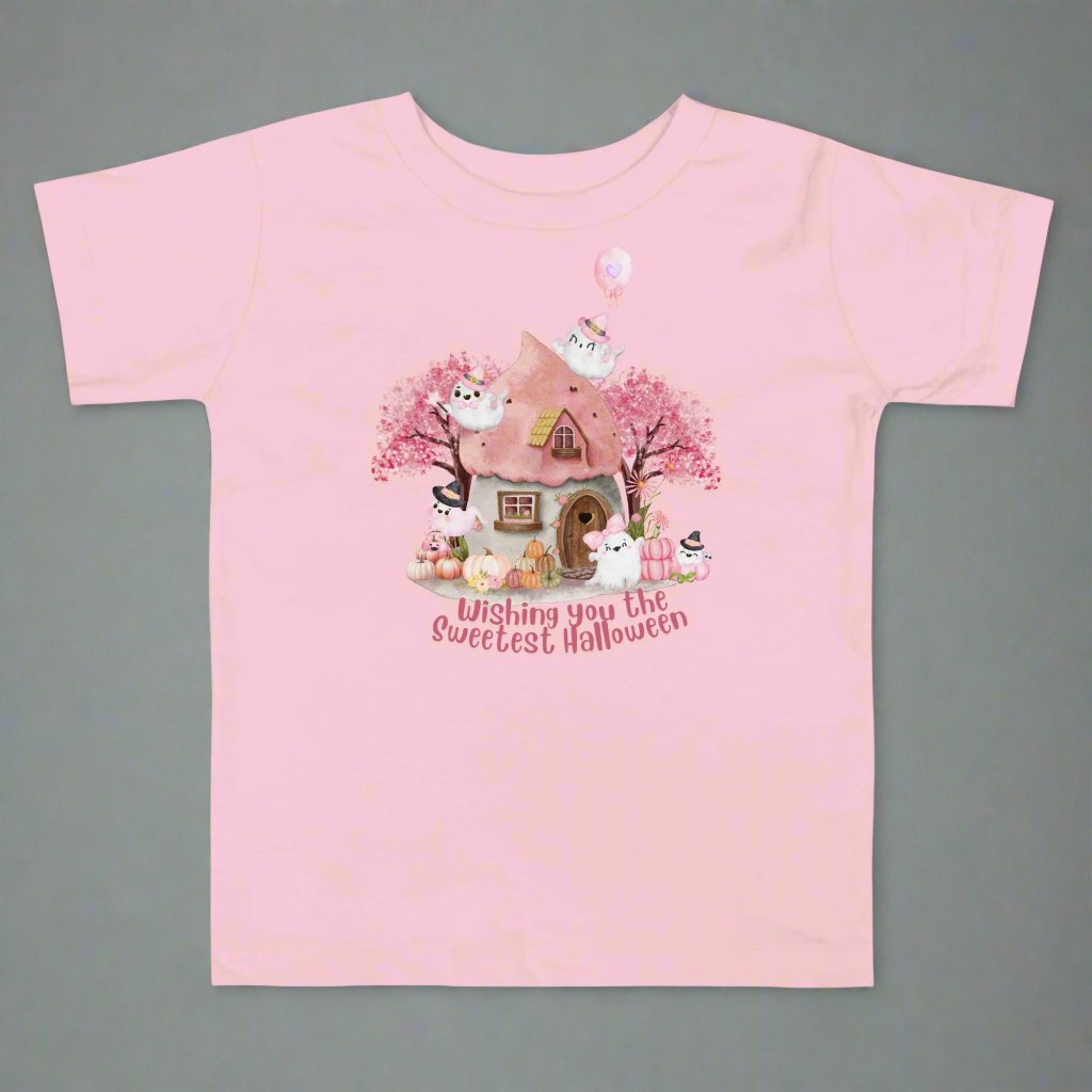 Pink toddler tshirt with a storybook cottage, pink trees, pink pumpkins and five sweet ghosts. The text reads Wishing you the sweetest halloween, by jaecrece