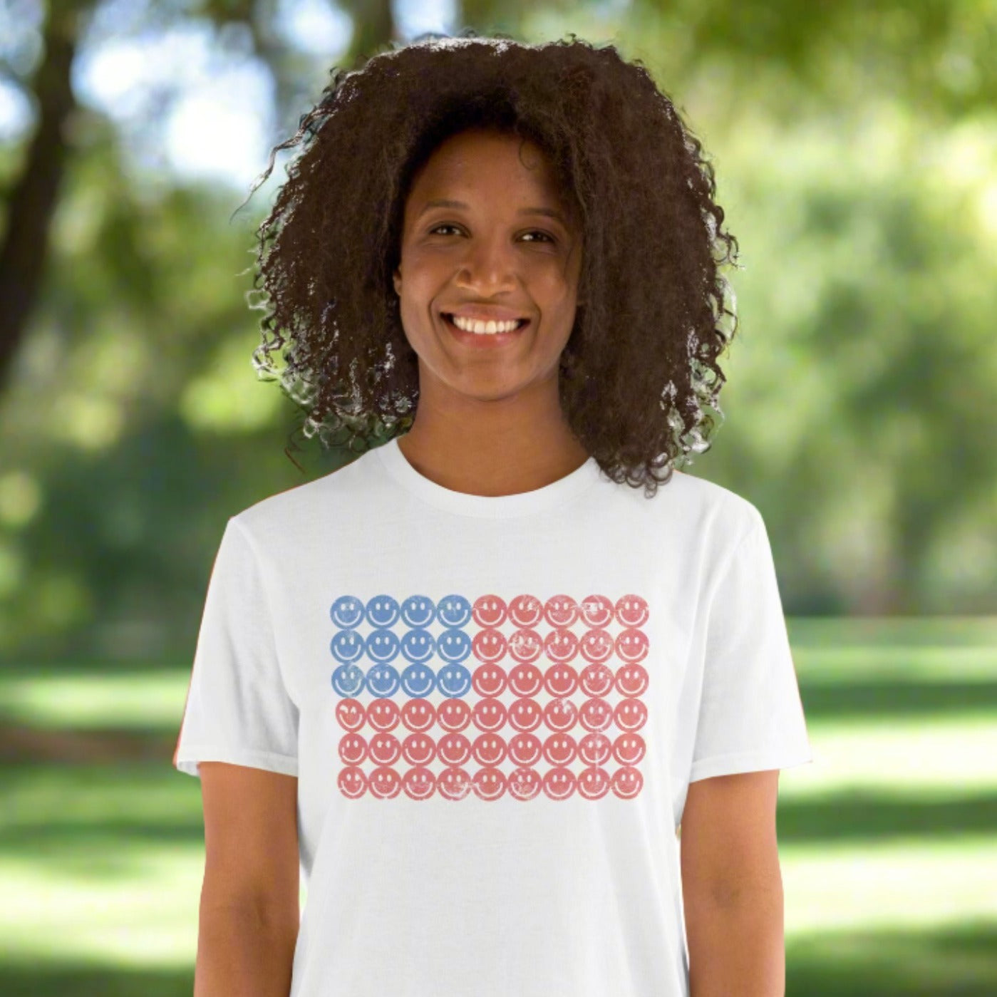 White adult tshirt, featuring a Fourth of July pattern of red and blue smiley faces which form an American flag. by jaecrece.com