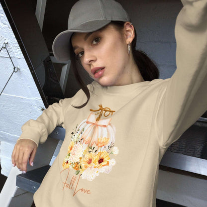 Fall Love Ladies Sweatshirt, this is a Sand colored Gildan Sweatshirt, with a graphic of a white pumpkin with a peach ribbon. The pumpkin is surrounded by a garland of fall leaves and flowers, with the text- Fall Love, by jaecrece