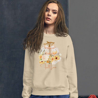 Fall Love Ladies Sweatshirt, this is a Sand colored Gildan Sweatshirt, with a graphic of a white pumpkin with a peach ribbon. The pumpkin is surrounded by a garland of fall leaves and flowers, with the text- Fall Love, by jaecrece