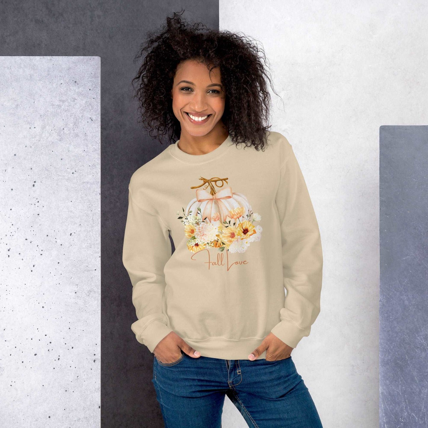 Fall Love Ladies Sweatshirt, this is a Sand colored Gildan Sweatshirt, with a graphic of a white pumpkin with a peach ribbon. The pumpkin is surrounded by a garland of fall leaves and flowers, with the text- Fall Love, by jaecrece