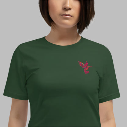 Model wearing a forest green embroidered shirt with a pink hummingbird stitched on the chest. This lightweight cotton tee is perfect for nature lovers and fans of slow fashion. With a pre-shrunk fit and breathable fabric, this unisex shirt in sizes XS–5XL makes a great gift for bird lovers, eco-conscious shoppers, and those who love embroidered t-shirts.