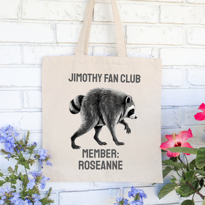 Personalized Jimothy raccoon tote bag displayed as a fun everyday canvas shopping bag with Jimothy Fan Club lettering and custom member name. Reusable cotton tote for groceries, books, shopping, farmers markets, and fans of the viral Seattle raccoon.