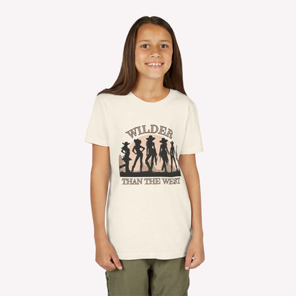 Youth girls western shirt in natural color featuring a strong “Wilder than the West” graphic with cowgirl silhouettes and a desert cactus sunset. Comes in sizes S–XL and is part of a fun mommy and me set for mini rodeo queens and southern girls. This vintage vibe tee is perfect for music festivals, horse lovers, Texas fairs, and bachelorette trip looks. Stylish graphic wear for bold, country-loving girls.