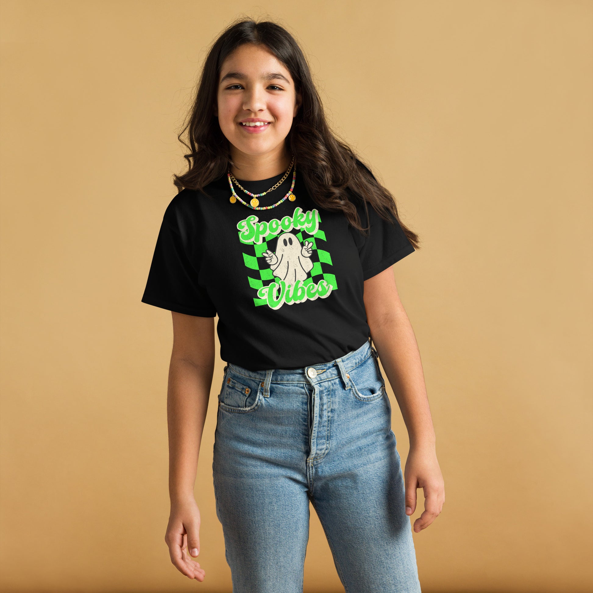 Black Spooky Vibes Child Shirt with a bright green checkerboard pattern and a cute ghost showing the peace sign. The text reads Spooky Vibes. This Halloween tee is perfect for girls and boys! By jaecrece