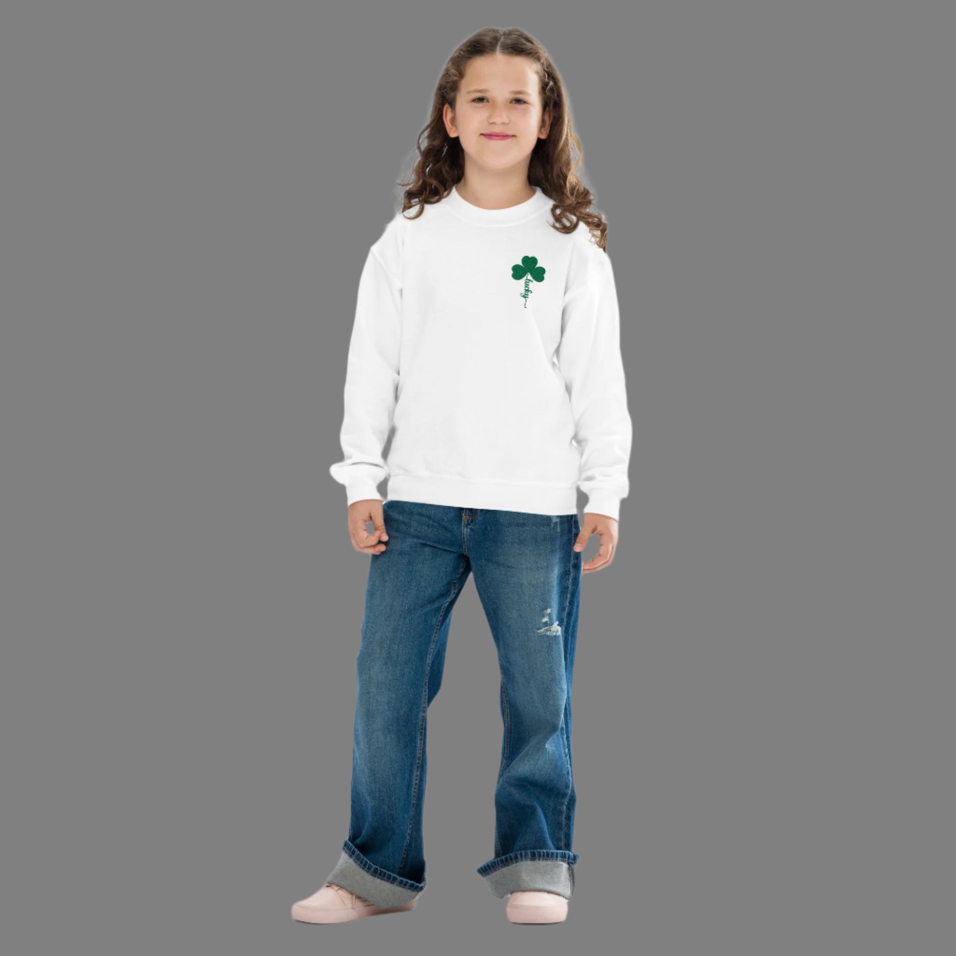 Image: St Patricks Day Emboidered Shamrock Lucky Sweatshirt. This white crewneck pullover has embroidered green four leaf clover, and stem of the  clover spells Lucky. Available in sizes for toddlers, girls, boys tweens, by jaecrece