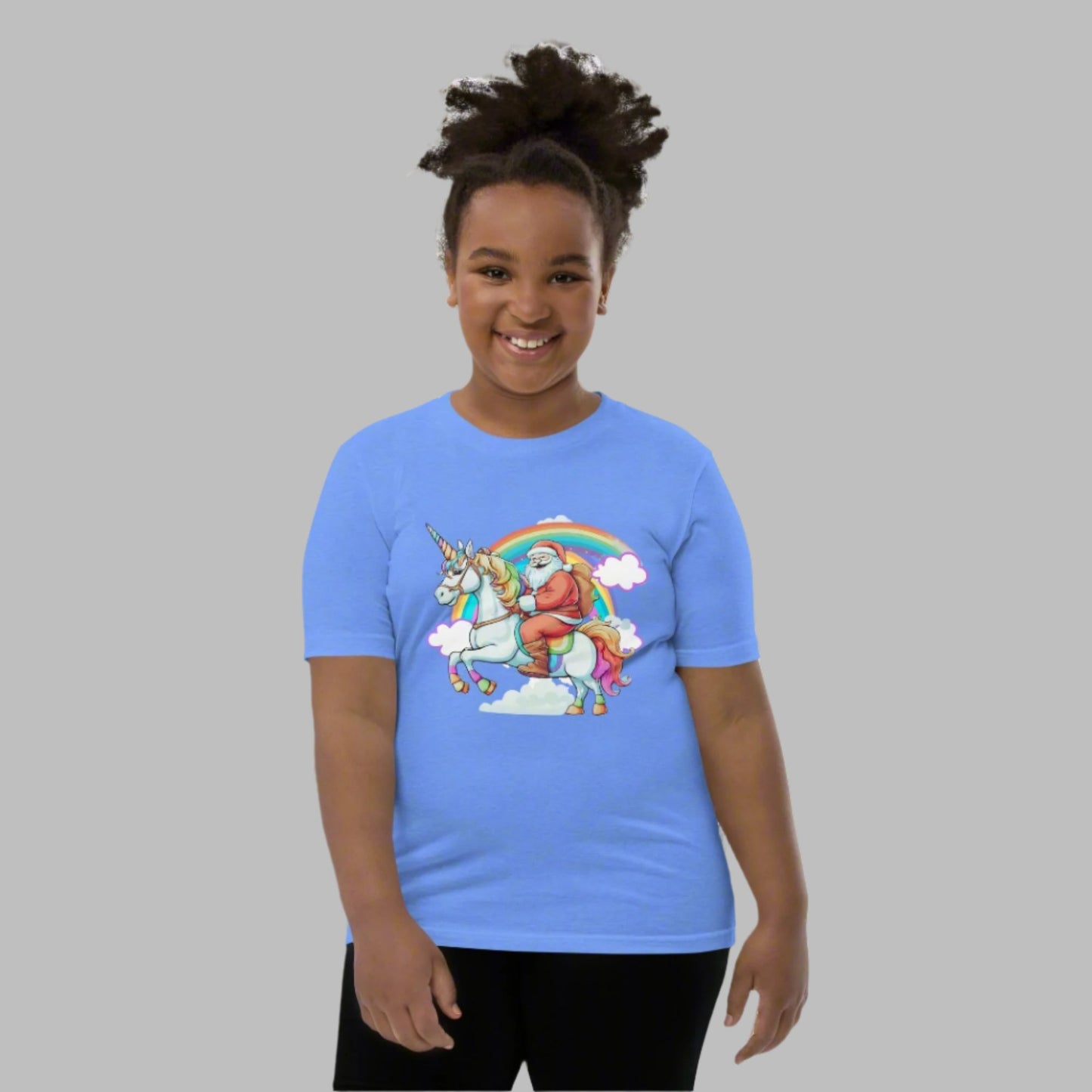 Alt Text: Blue short sleeve youth tshirt, featuring a whimsical scene of Santa riding on a unicorn over a rainbow with clouds