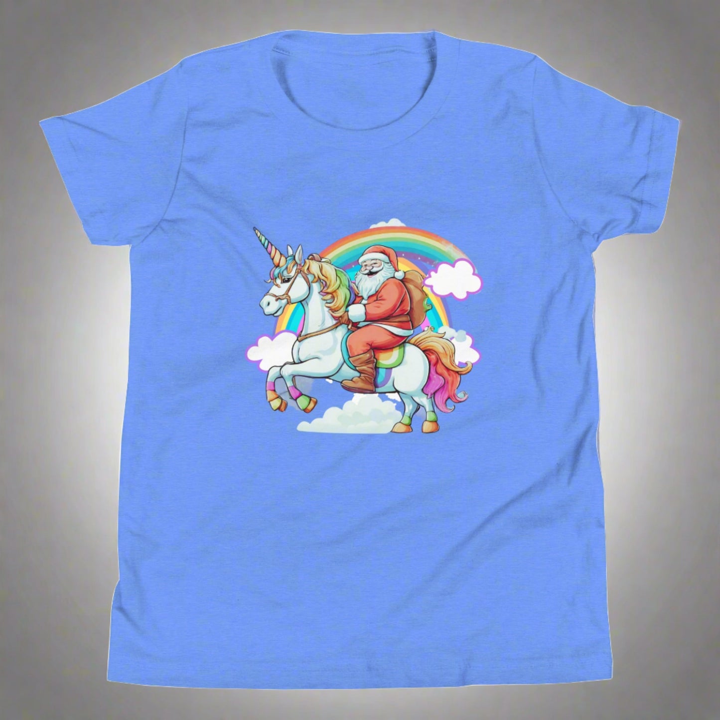 Alt Text: Blue short sleeve youth tshirt, featuring a whimsical scene of Santa riding on a unicorn over a rainbow with clouds