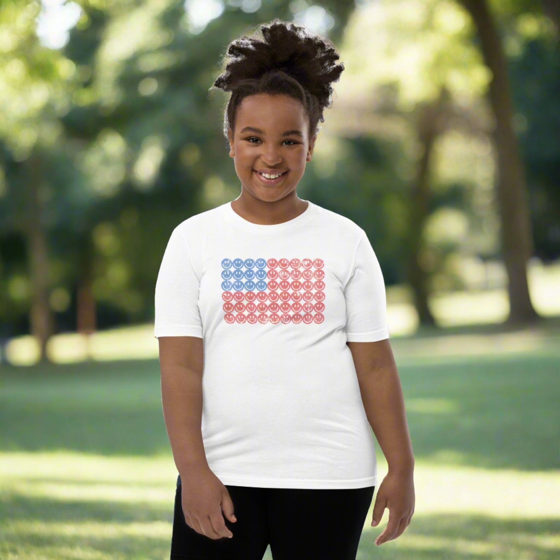 White unisex patriotic shirt for boys and girls. The graphic is an American flag, made up of Blue and Red Vintage smiley faces, by jaecrece.com