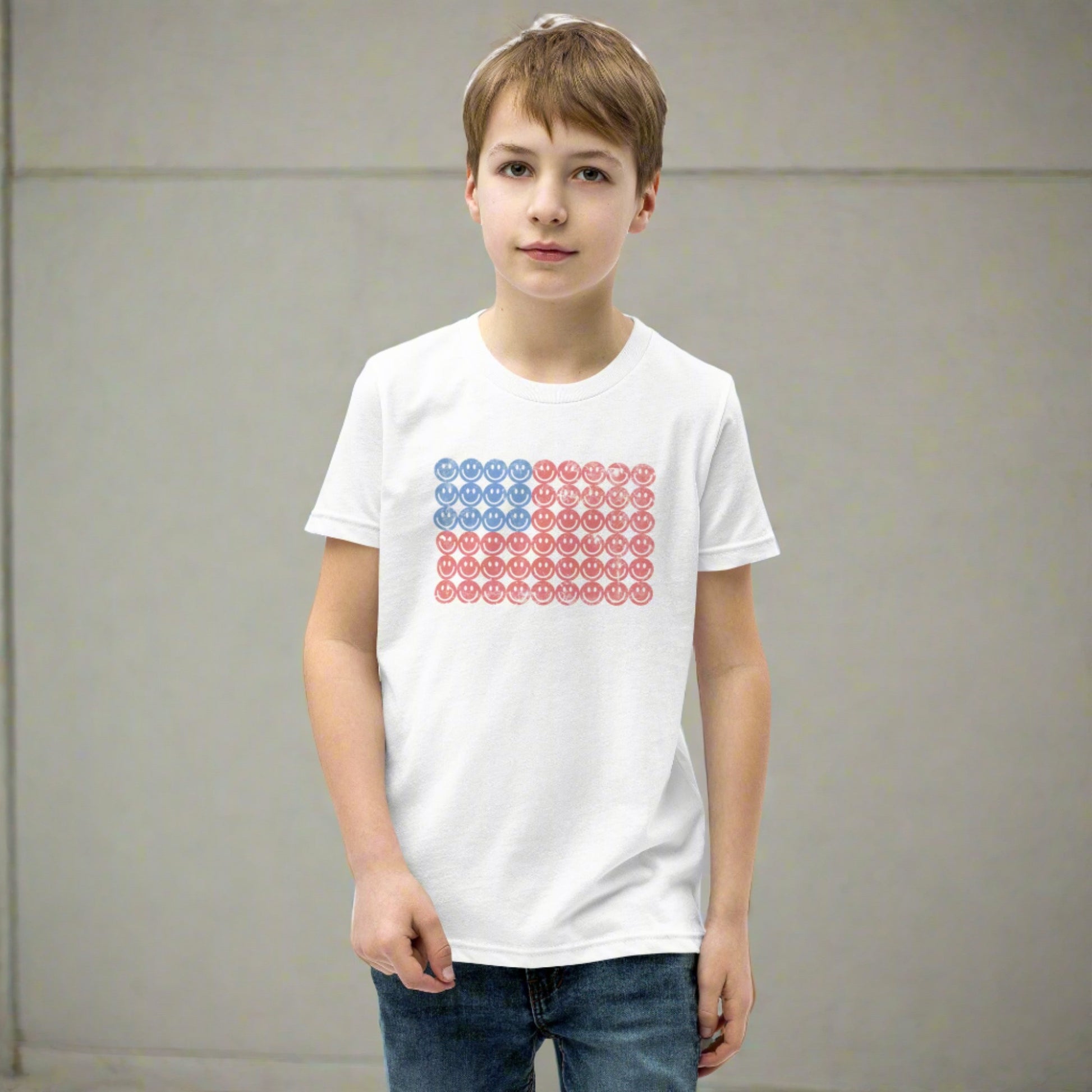 White unisex patriotic shirt for boys and girls. The graphic is an American flag, made up of Blue and Red Vintage smiley faces, by jaecrece.com