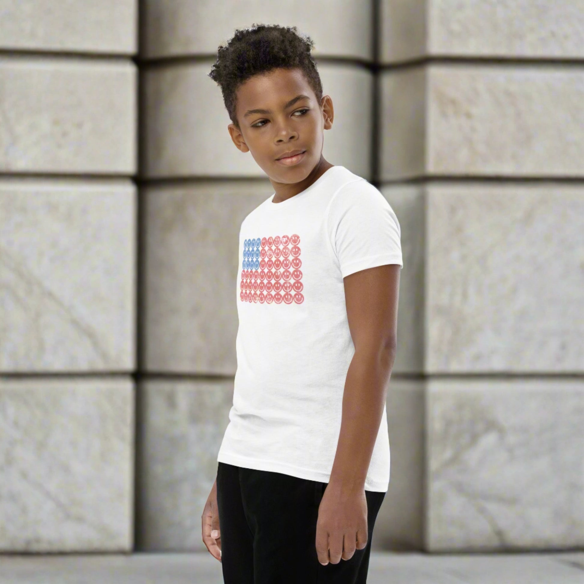 White unisex patriotic shirt for boys and girls. The graphic is an American flag, made up of Blue and Red Vintage smiley faces, by jaecrece.com